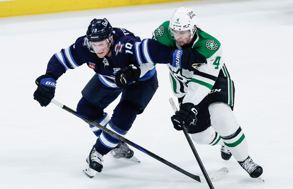 Winnipeg Jets' Jonathan Toews (19) and Dallas Stars' Miro Heiskanen (4) battle for the puck during second-period NHL hockey game action in Winnipeg, Manitoba, Thursday, Oct. 9, 2025. (John Woods/The Canadian Press via AP)
