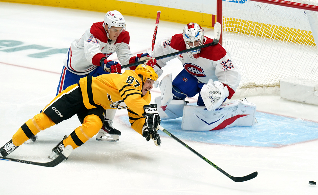 Pittsburgh Penguins' Sidney Crosby (87) reaches for the puck during the first period of an NHL hockey game against the Montréal Canadiens, Thursday, Dec. 11, 2025, in Pittsburgh. (Matt Freed/Pittsburgh Post-Gazette via AP)
