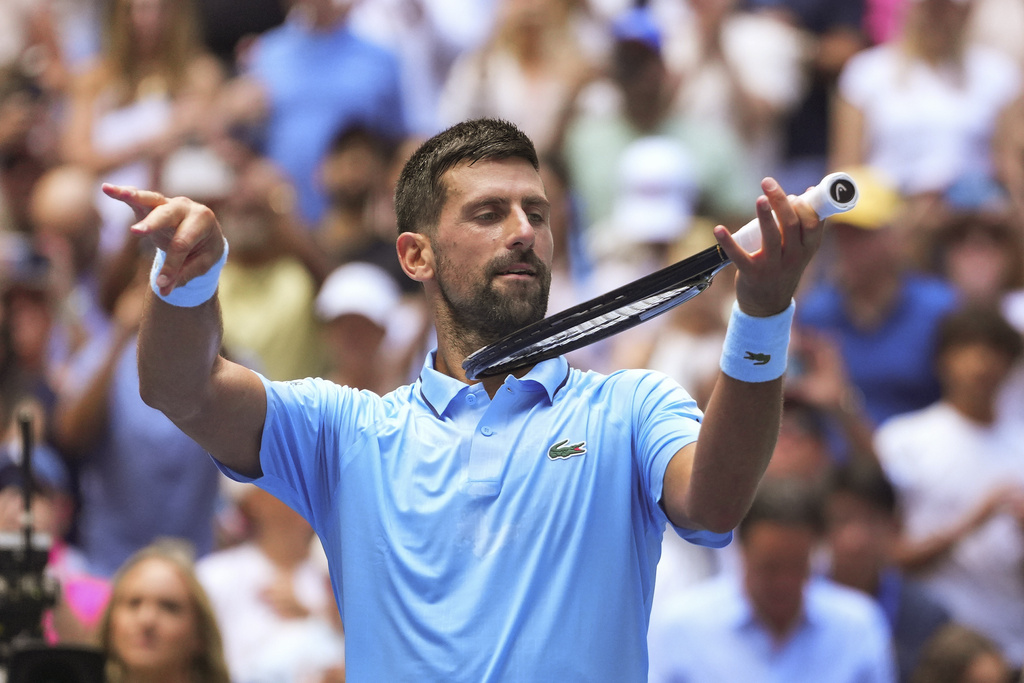 Novak Djokovic, of Serbia, pretends to play the violin after defeating Zachary Svajda, of the United States, during the second round of the U.S. Open tennis championships, Wednesday, Aug. 27, 2025, in New York. (AP Photo/Kirsty Wigglesworth)
