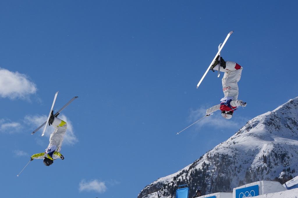 Canada's Mikael Kingsbury (4), right, and Kazakhstan's Pavel Kolmakov (10) compete during the men's freestyle skiing dual moguls finals at the 2026 Winter Olympics, in Livigno, Italy, Sunday, Feb. 15, 2026. (AP Photo/Gregory Bull)