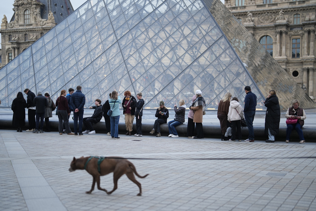 FILE - People wait for the Louvre museum to open as employees at the Louvre Museum vote to extend a strike that has disrupted operations at the world's most visited museum, Thursday, Dec. 18, 2025 in Paris. (AP Photo/Thibault Camus, File)