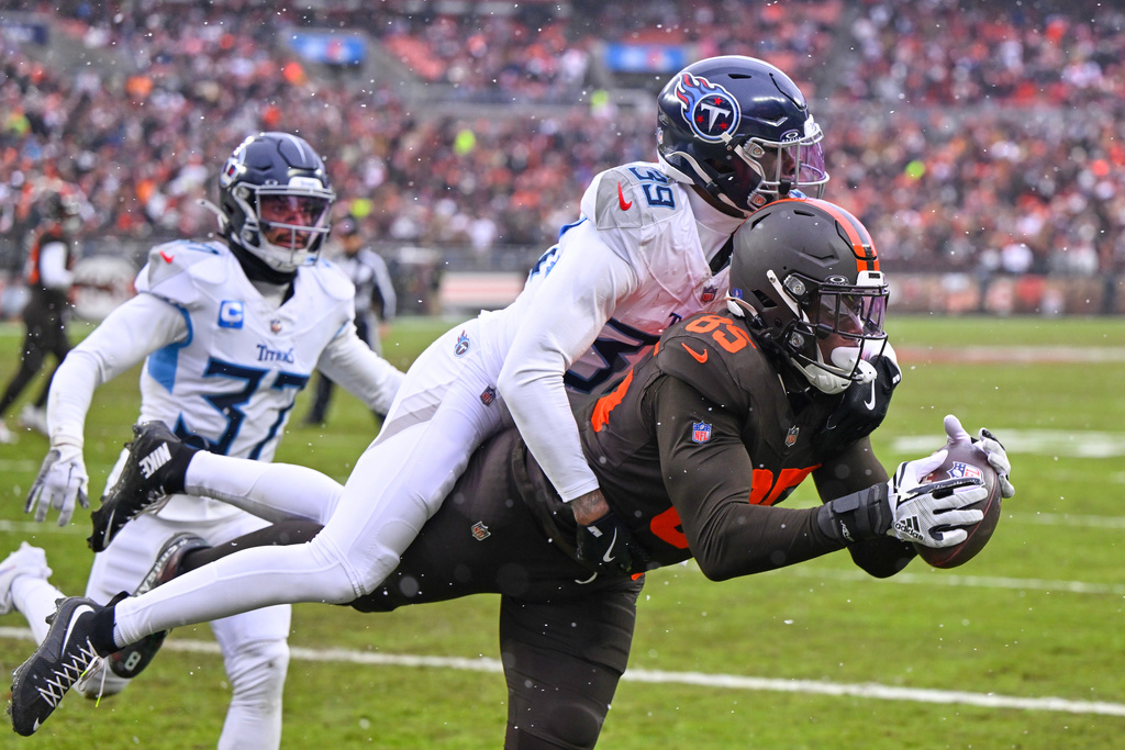 Cleveland Browns tight end David Njoku (85) catches a touchdown pass as Tennessee Titans cornerback Darrell Baker Jr. (39) defends in the first half of an NFL football game in Cleveland, Sunday, Dec. 7, 2025. (AP Photo/David Richard)