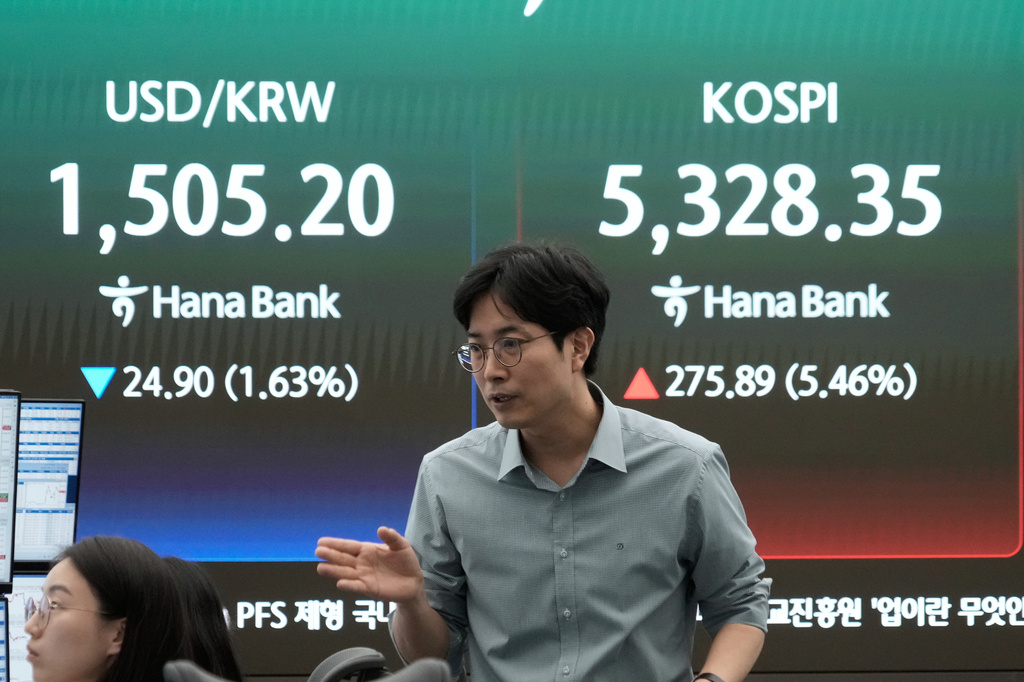 A currency trader reacts near a screen showing the Korea Composite Stock Price Index (KOSPI), right, and the foreign exchange rate between U.S. dollar and South Korean won at the foreign exchange dealing room of the Hana Bank headquarters in Seoul, South Korea, Wednesday, April 1, 2026. (AP Photo/Ahn Young-joon)
