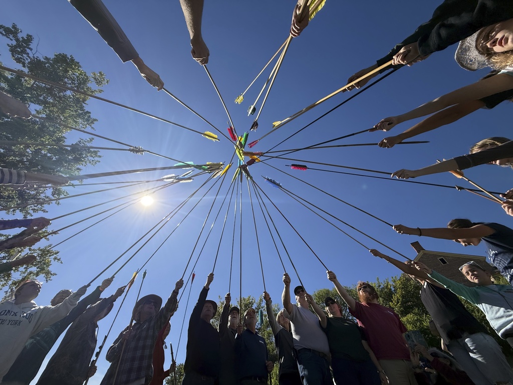 Competitors raise their darts as part of the opening ceremony for the Northeastern Atlatl Championship in Addison, Vt., Saturday, Sept. 20, 2025. (AP Photo/Amanda Swinhart)