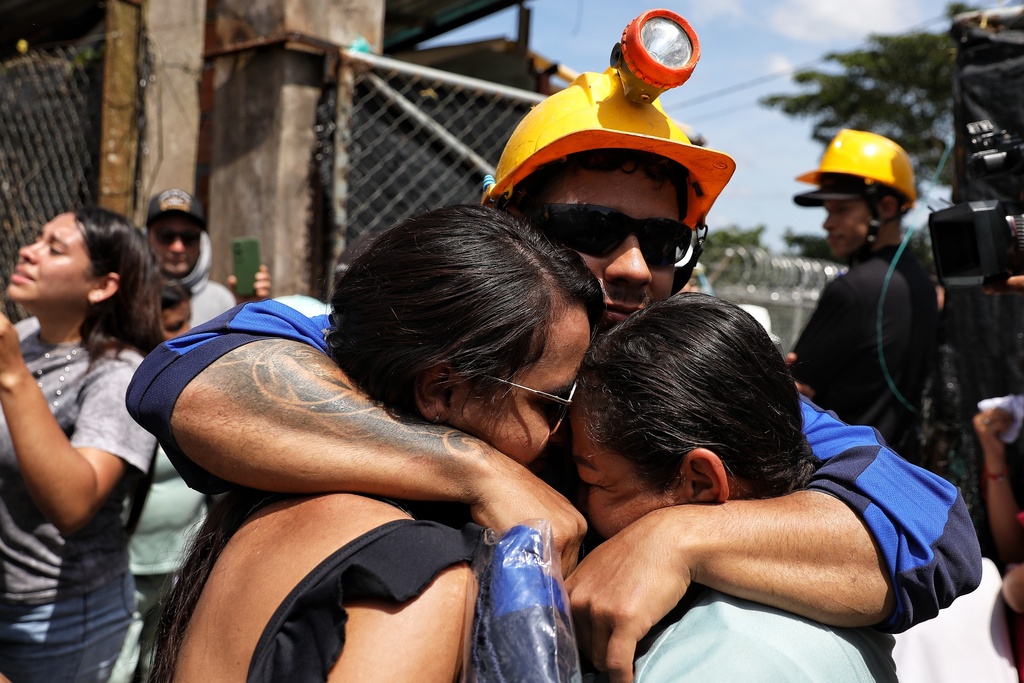 A miner embraces his relatives after he was rescued from a gold mine that had collapsed in Segovia, Colombia, Wednesday, Sept. 24, 2025. (AP Photo/Santiago Saldarriaga)
