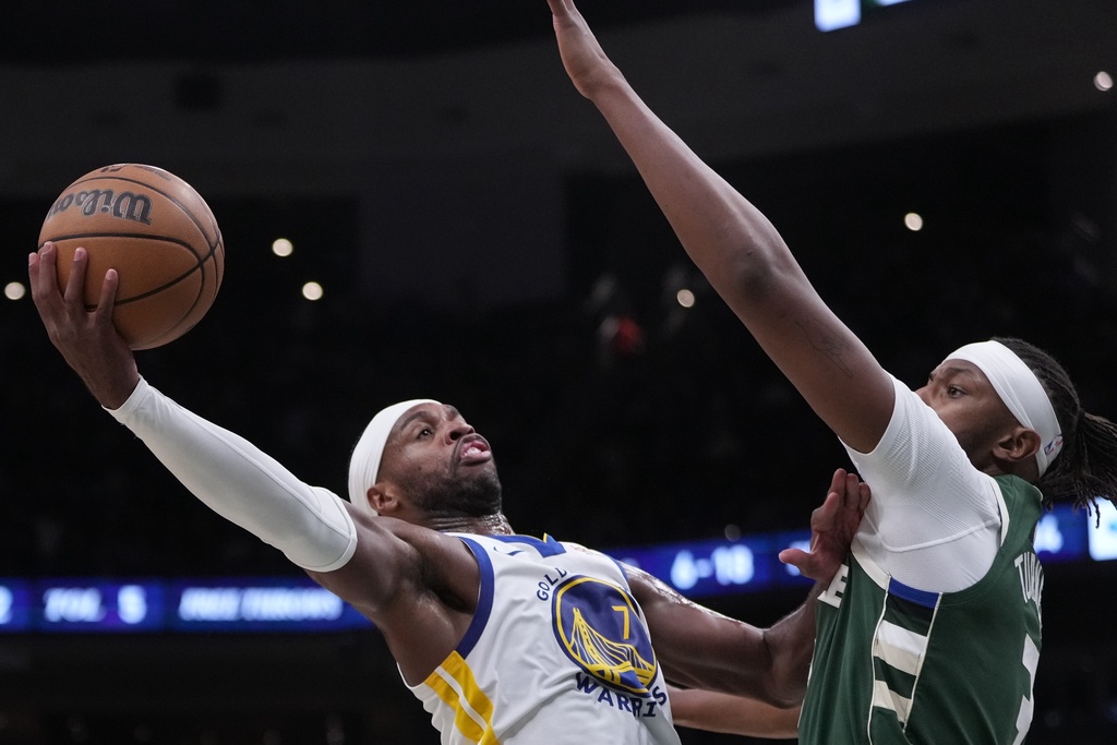 Golden State Warriors' Buddy Hield shoots past Milwaukee Bucks' Myles Turner during the first half of an NBA basketball game Thursday, Oct. 30, 2025, in Milwaukee. (AP Photo/Morry Gash)