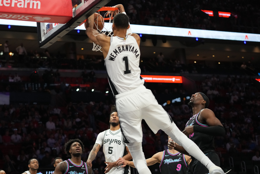 San Antonio Spurs forward Victor Wembanyama (1) dunks over Miami Heat center Bam Adebayo, right, during the first half of an NBA basketball game, Monday, March 23, 2026, in Miami. (AP Photo/Lynne Sladky)