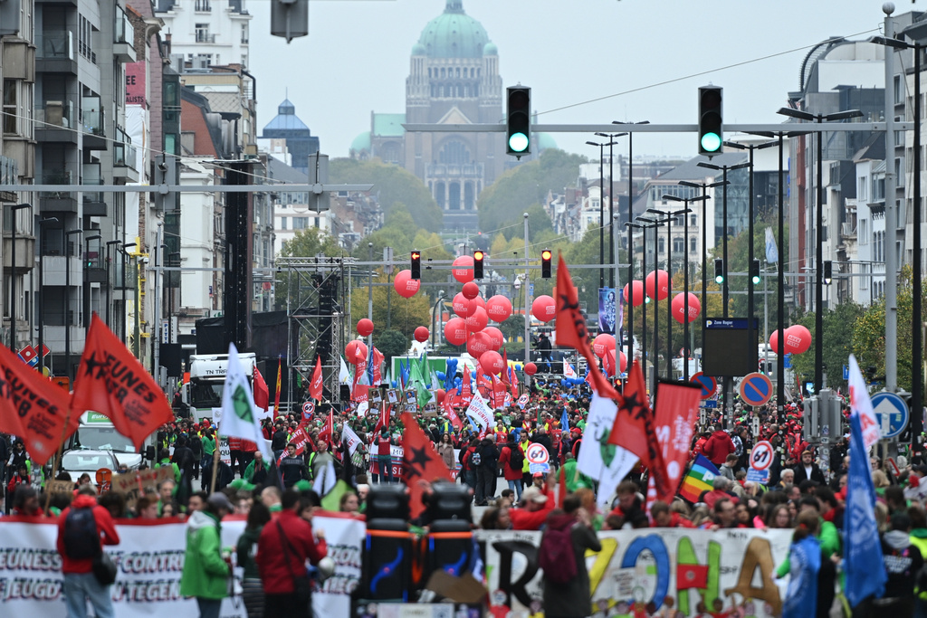 People march with signs crossed out with the number 67, referring to pension age, during a demonstration and general strike in Brussels, Tuesday, Oct. 14, 2025. (AP Photo/Harry Nakos)