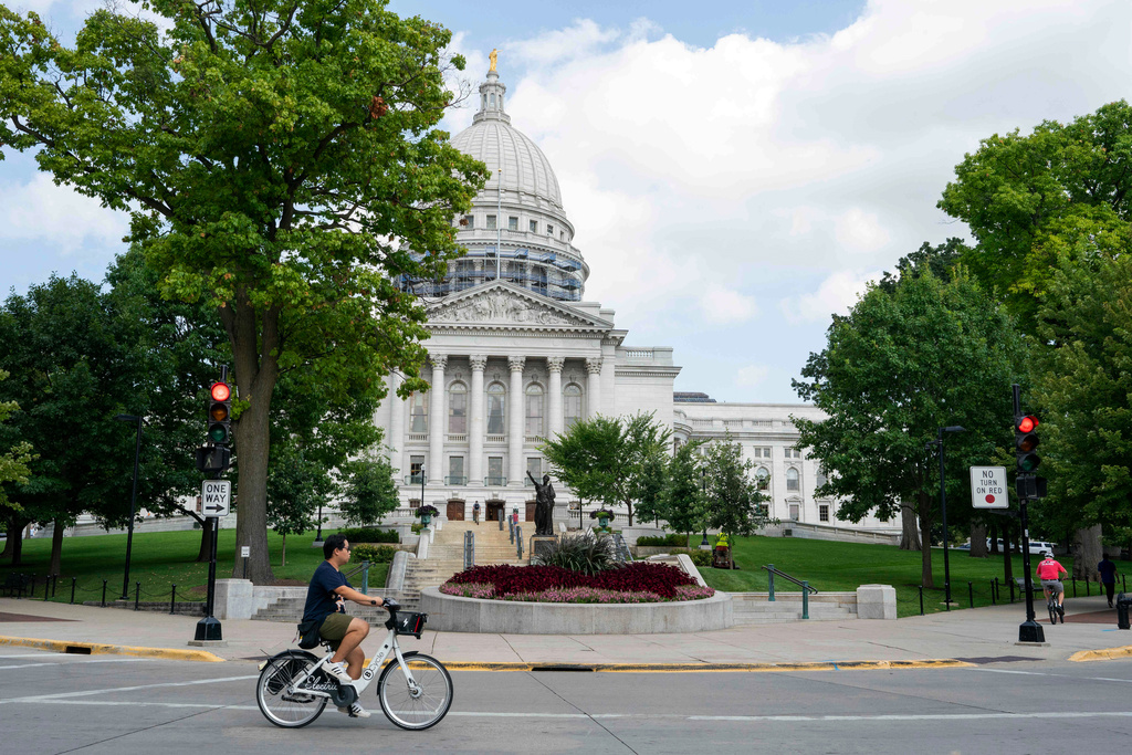FILE - A cyclist rides past the Wisconsin State Capitol on July 30, 2024, in Madison, Wis. (AP Photo/Kayla Wolf, File)