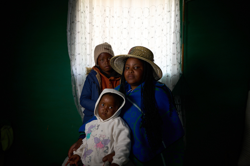 Matseliso Lekhoele, 36, who is HIV-positive, poses for a portrait with her two children, Bohlokoa, 8, and Maseabata, 4, inside their home in Thaba-Tsoeu, Lesotho, Sunday, July 13, 2025. Both her children are HIV-negative, with help from U.S.-funded HIV prevention programs. Since the aid cuts, pregnant and breastfeeding mothers have lost access to such programs, putting babies at risk. (AP Photo/Bram Janssen)