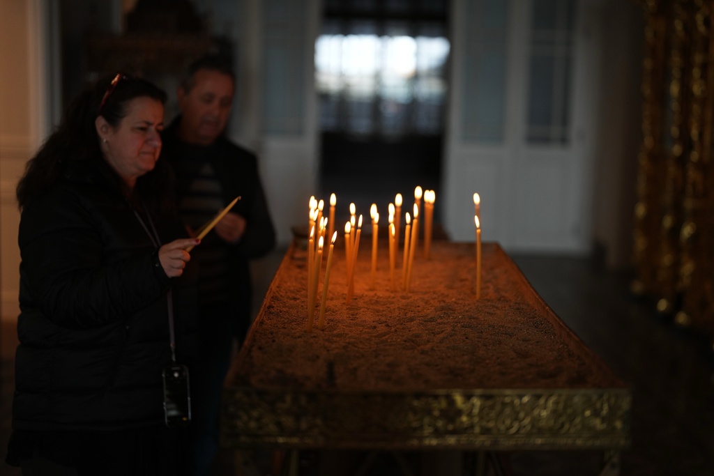 Greek pilgrims light candles at the Christian Orthodox Halki Theological school at the Holy Trinity Monastery, in Heybeliada island, Istanbul, Turkey, Friday, Nov. 14, 2025. (AP Photo/Francisco Seco)