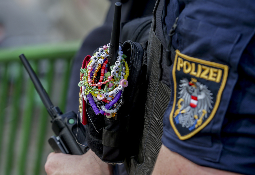 FILE - A police officer is decorated with Taylor Swift bracelets while guarding the city center in Vienna on Aug. 8, 2024. (AP Photo/Heinz-Peter Bader, File)