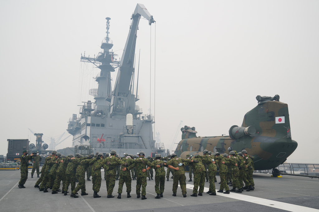 Crew members huddle on the deck of Japanese tank landing ship JS Kunisaki amid haze from wildfires, after its arrival at Kijing Port in Mempawah, West Kalimantan, Indonesia, Thursday, Sept. 10, 2026. (AP Photo/Tatan Syuflana)
