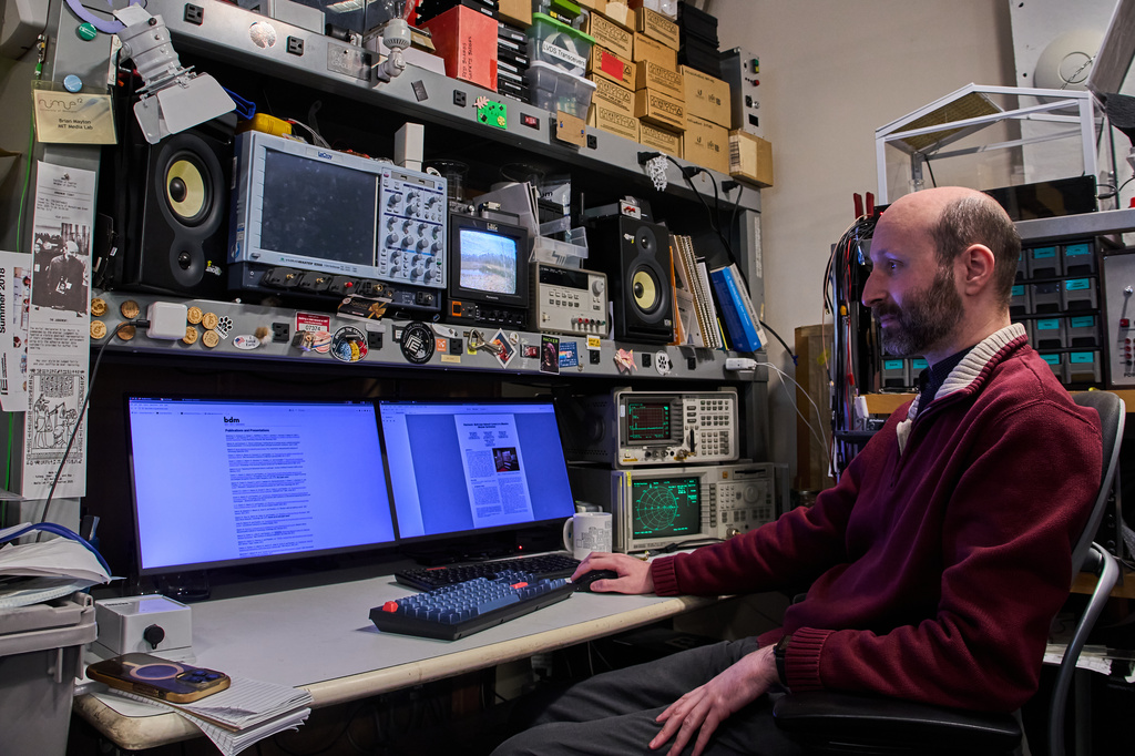 Brian Mayton, a member of the Living Observatory and research affiliate at Massachusetts Institute of Technology Media Lab, reads research papers at his desk at MIT, Wednesday, March 25, 2026 in Cambridge Mass. (Jamie Jiang/MIT Graduate Program in Science Writing via AP)