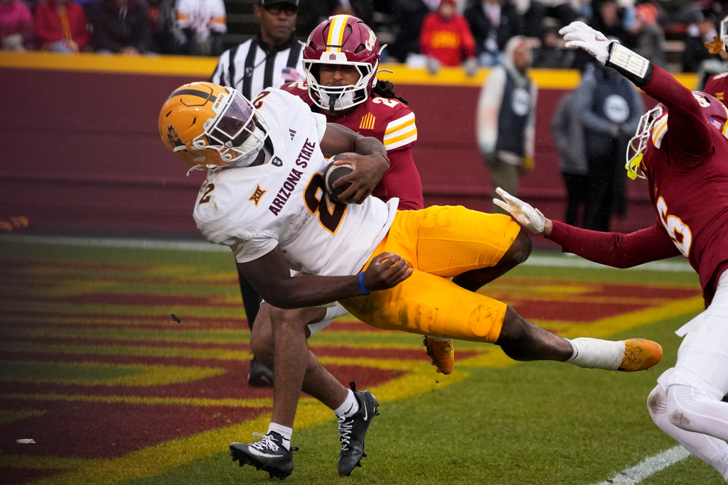Arizona State quarterback Jeff Sims scores on a touchdown run in front of Iowa State defensive back Jamison Patton, rear, during the first half of an NCAA college football game, Saturday, Nov. 1, 2025, in Ames, Iowa. (AP Photo/Charlie Neibergall)