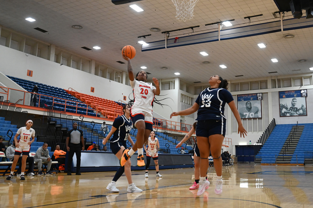 Morgan State guard Michaela Bogans (20) scores as Washington Adventist University forward Tye Queen (33) looks on during an NCAA college basketball game, Wednesday, Nov 12, 2025, in Baltimore. (AP Photo/Gail Burton)