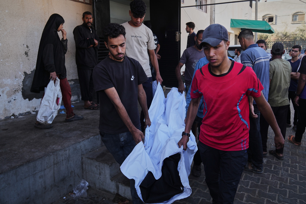 Palestinians carry the body of their relative, killed in an Israeli military strike, at the Al-Aqsa Hospital in Deir al-Balah, central Gaza Strip, Tuesday, Sept. 30, 2025. (AP Photo/Abdel Kareem Hana)