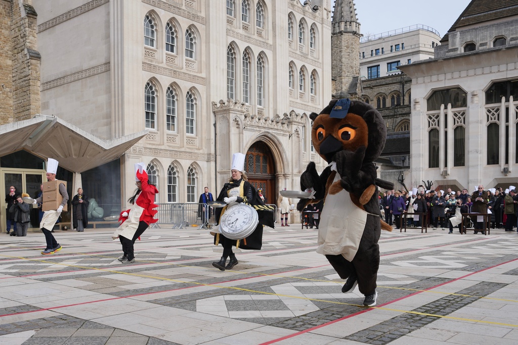 Competitors participate a traditional pancake race by livery companies at the Guildhall in London, Tuesday, Feb. 17, 2026. (AP Photo/Kin Cheung)