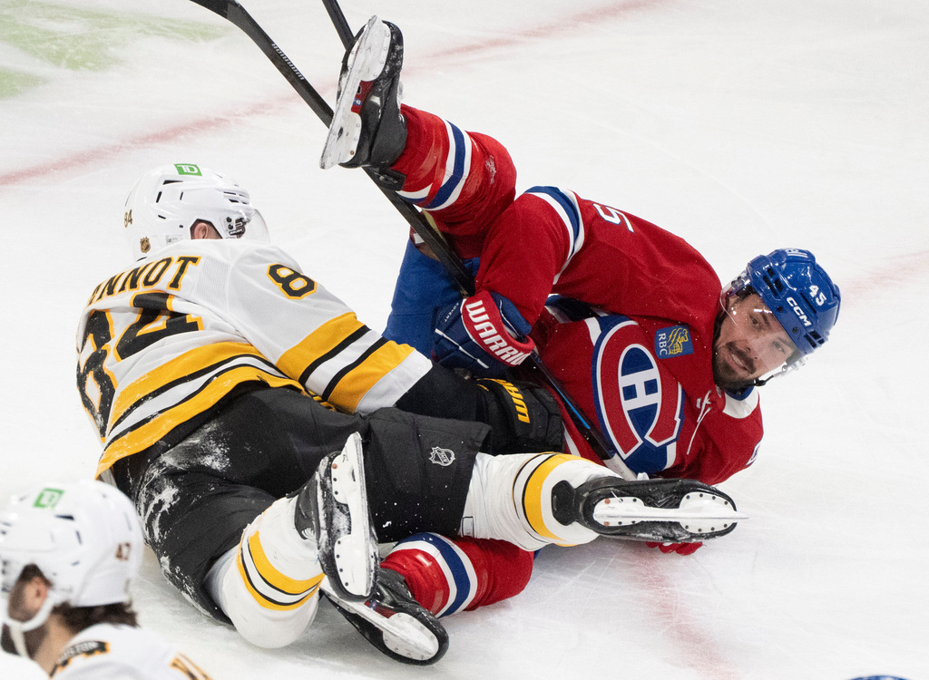 Montreal Canadiens' Alexandre Carrier (45) and Boston Bruins' Tanner Jeannot (84) get tangled up during second period NHL hockey action in Montreal, on Tuesday, March 17, 2026. (Christinne Muschi/The Canadian Press via AP)