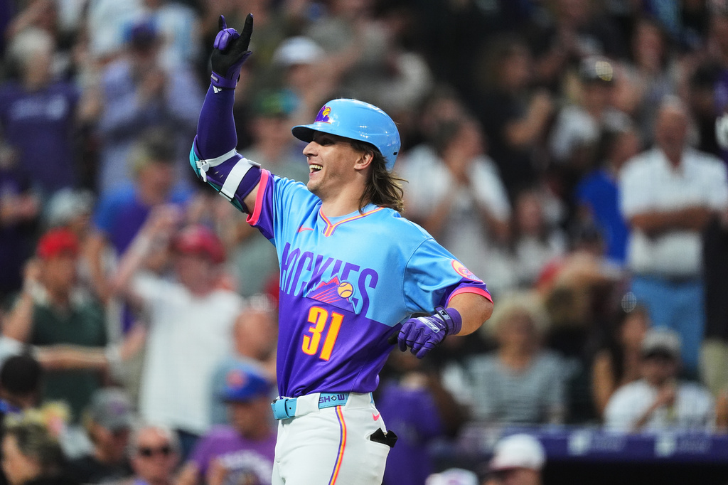 Colorado Rockies' Jake McCarthy gestures as he crosses home plate after hitting a grand slam off San Francisco Giants relief pitcher Matt Gage in the fifth inning of a baseball game Friday, July 3, 2026, in Denver. (AP Photo/David Zalubowski)