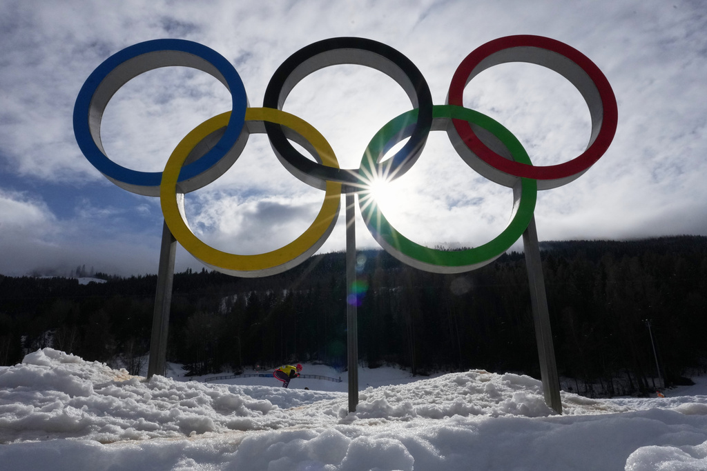 An athlete skis past Olympic rings during a cross country training session at the 2026 Winter Olympics, in Tesero, Italy, Thursday, Feb. 5, 2026. (AP Photo/Kirsty Wigglesworth)