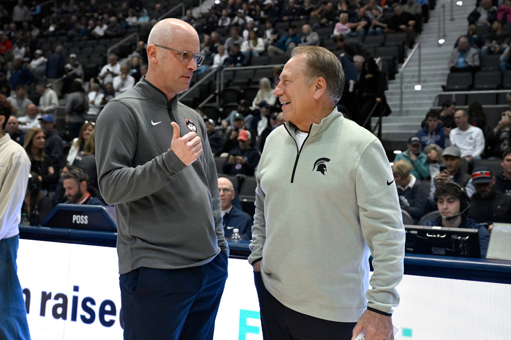 UConn head coach Dan Hurley, left, talks with Michigan State head coach Tom Izzo before an NCAA basketball game, Tuesday, Oct. 28, 2025, at PeoplesBank Arena in Hartford, Conn. (AP Photo/Jessica Hill)