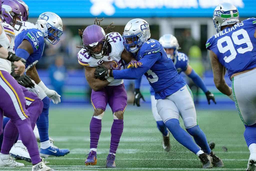 Seattle Seahawks linebacker Ernest Jones IV (13) tackles Minnesota Vikings running back Aaron Jones Sr. (33) during the second half of an NFL football game, Sunday, Nov. 30, 2025, in Seattle. (AP Photo/Stephen Brashear)