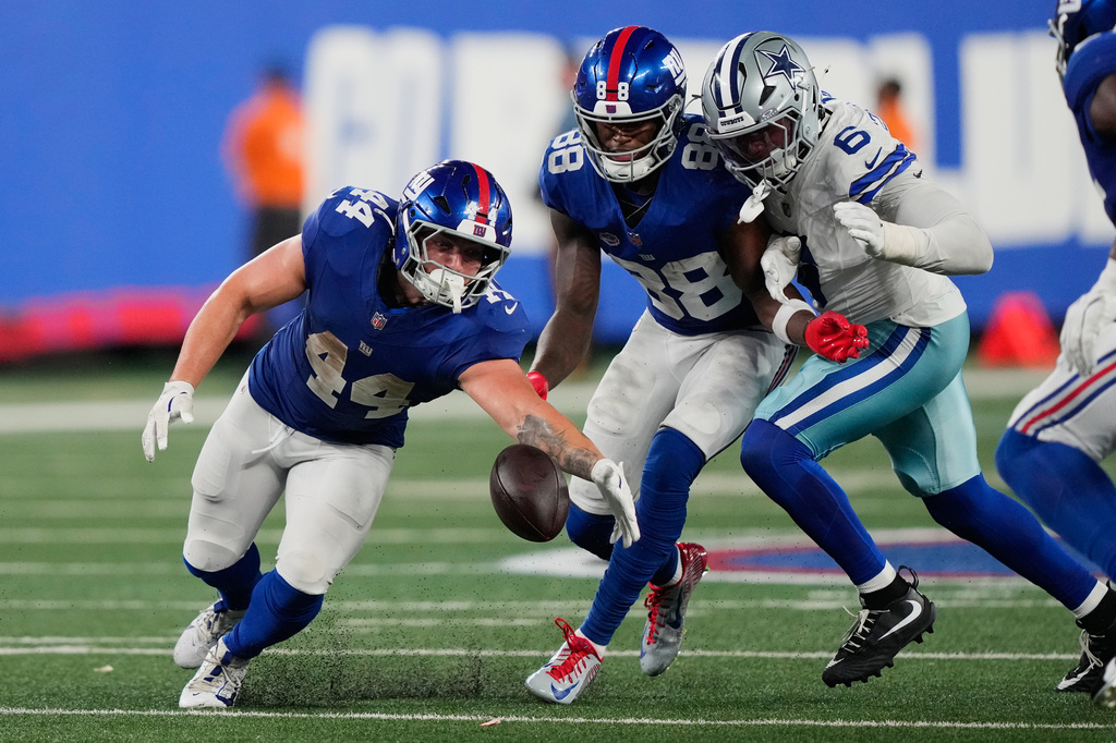 New York Giants running back Cam Skattebo (44) tries to recover his fumble as teammate wide receiver Malachi Fields (88) and Dallas Cowboys linebacker Donovan Ezeiruaku (6) try to get to the ball during the second half of an NFL football game Sunday, Sept. 13, 2026, in East Rutherford, N.J. (AP Photo/Yuki Iwamura)
