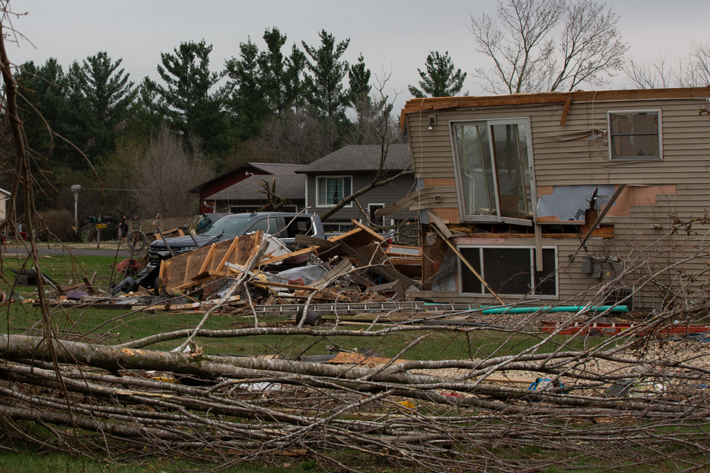 Debris and fallen tree limbs cover the ground after a severe storm that tore through the Upper Midwest on Friday, April 17, 2026, in Rochester, Minn. (Hollie Bennett Piotrowicz via AP)