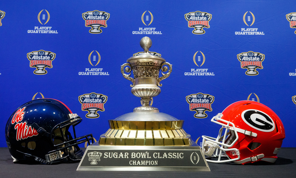 The Sugar Bowl Classic trophy is displayed between helmets from Ole Miss and Georgia during media availability in New Orleans, Tuesday, Dec. 31, 2025. (David Grunfeld /The Times-Picayune/The New Orleans Advocate via AP)