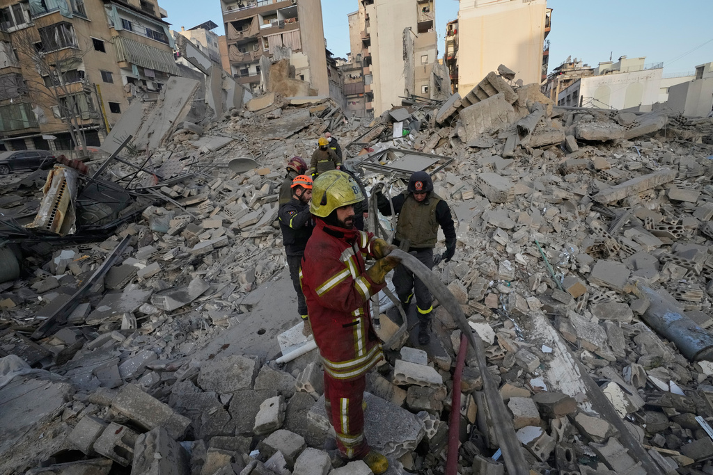 Firefighters and rescue workers work on the rubble of a building that was destroyed by an Israeli strike in central Beirut, Lebanon, Wednesday, March 18, 2026. (AP Photo/Hussein Malla)