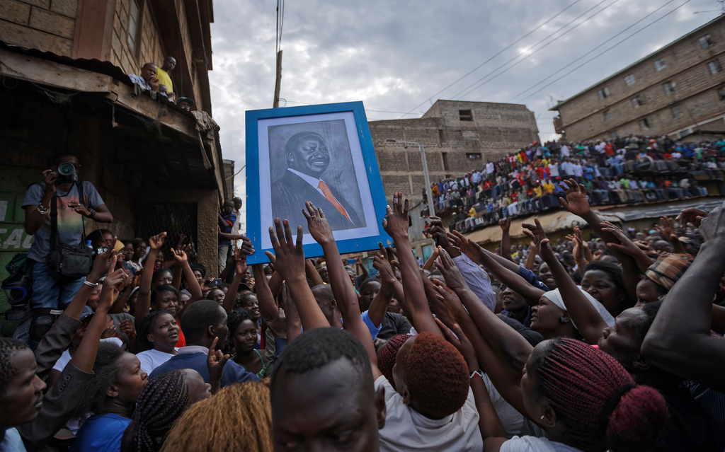 Supporters reach out to touch a painting of Kenyan opposition leader Raila Odinga, before he arrived to address thousands of supporters gathered in the Mathare area of Nairobi, Kenya, Sunday, Aug. 13, 2017. (AP Photo/Ben Curtis)
