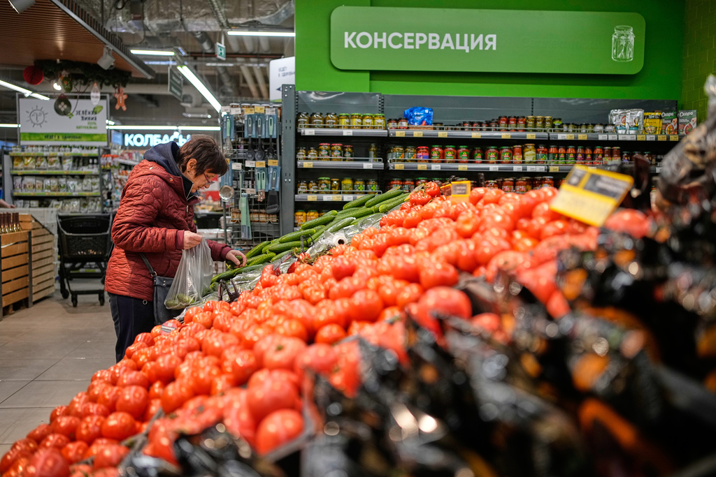 A woman picks up vegetables in a supermarket in Moscow, Russia, Thursday, Nov. 20, 2025. (AP Photo/Pavel Bednyakov)