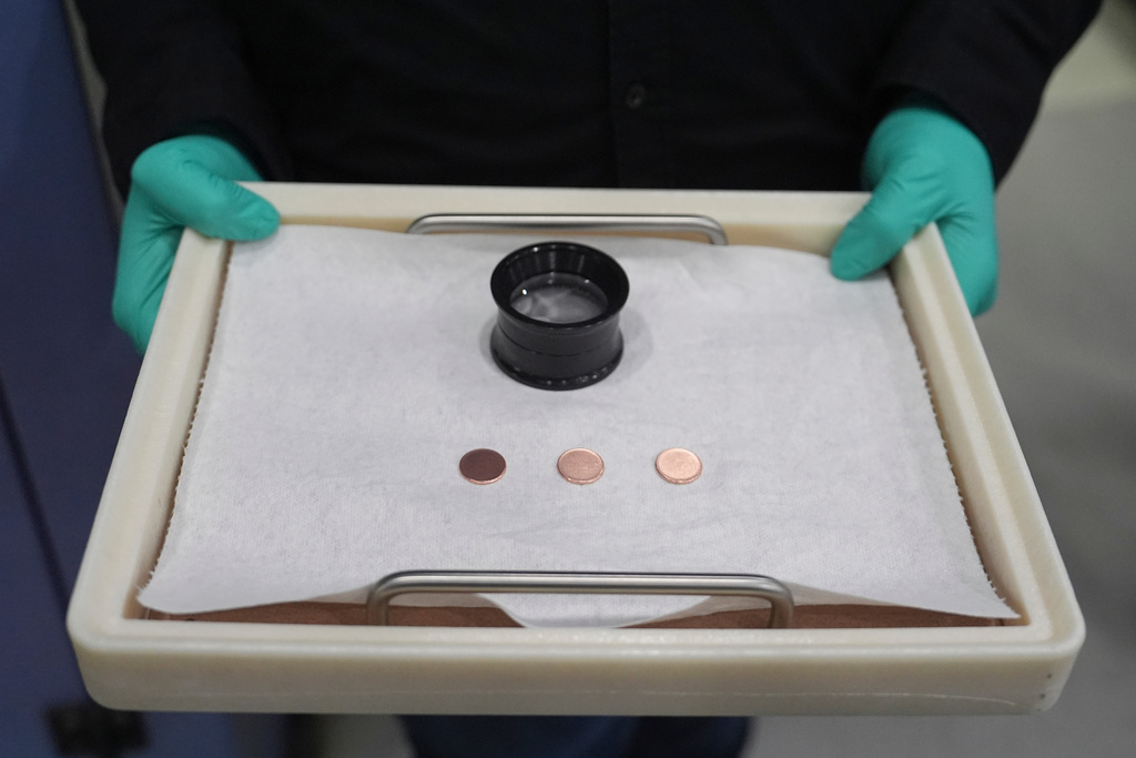FILE - Blank coins wait to be the last pennies pressed at the U.S. Mint, in Philadelphia, Nov. 12, 2025. (AP Photo/Matt Slocum, File)