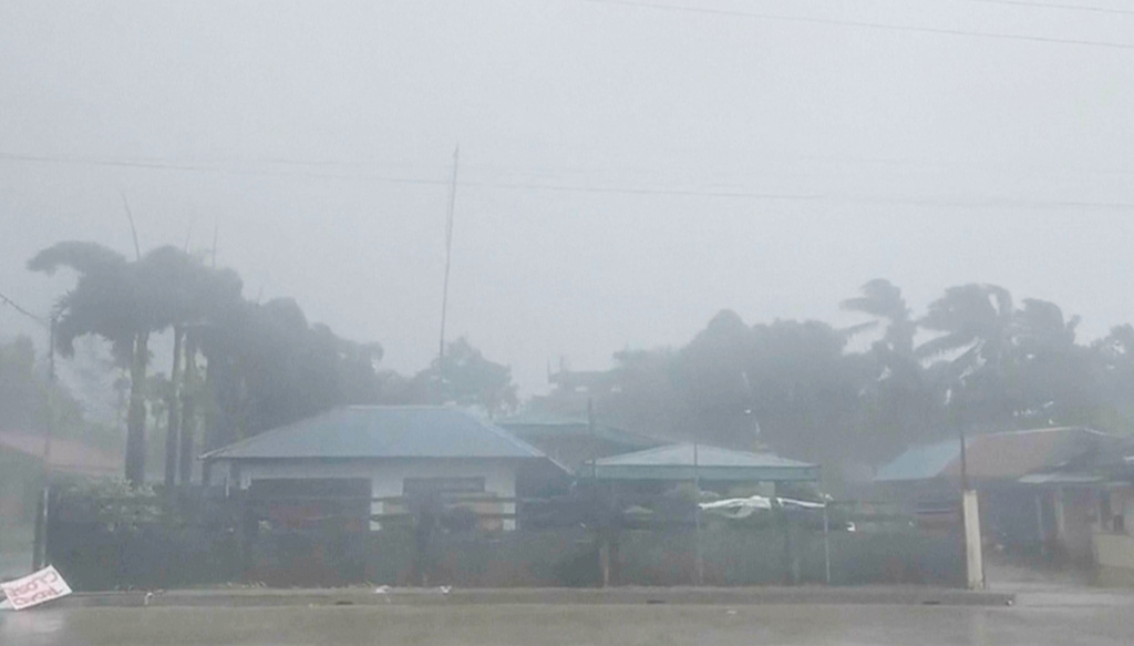 This grab from video shows buildings and trees being blown during storm in Dinapigue, Isabela province, Philippines, Friday, Oct.3, 2025. (Benson Ingaran Milare via AP)