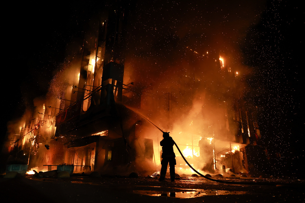 A rescue worker puts out a fire at the Intrade trade center after a Russian drone strike on Zaporizhzhia, Ukraine, Monday, Sept. 21, 2026. (AP Photo/Kateryna Klochko) Correction: Byline corrected to Kateryna Klochko, instead of Evgeniy Maloletka