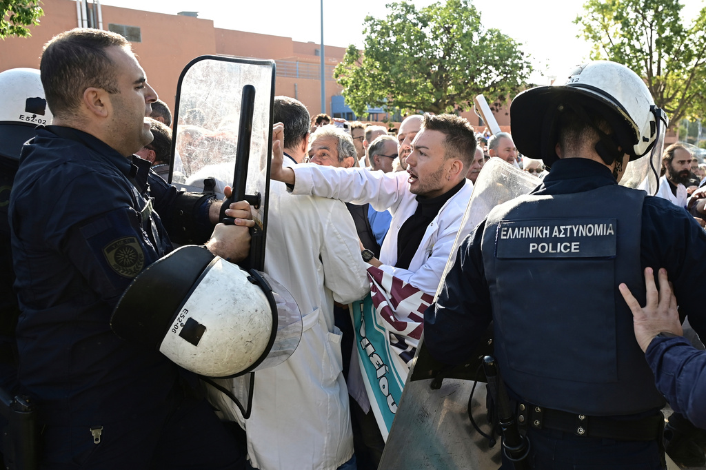 Medical workers scuffle with riot police after the staff gathered to protest the state of public health services during a visit to the hospital by the country's prime minister in Athens, Greece, Wednesday, Oct. 15, 2025. (Michalis Karayiannis/Eurokinissi via AP)