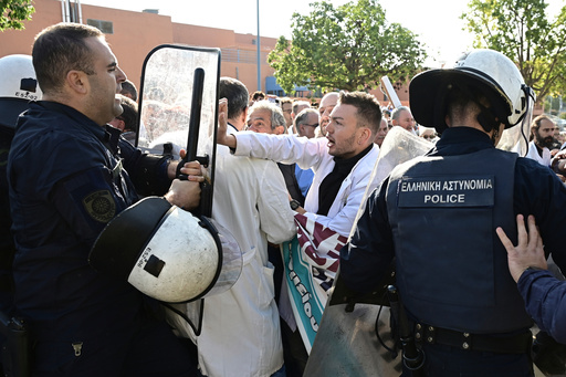 Medical workers scuffle with riot police after the staff gathered to protest the state of public health services during a visit to the hospital by the country's prime minister in Athens, Greece, Wednesday, Oct. 15, 2025. (Michalis Karayiannis/Eurokinissi via AP) Medical workers scuffle with riot police after the staff gathered to protest the state of public health services during a visit to the hospital by the country's prime minister in Athens, Greece, Wednesday, Oct. 15, 2025. (Michalis Karayiannis/Eurokinissi via AP)