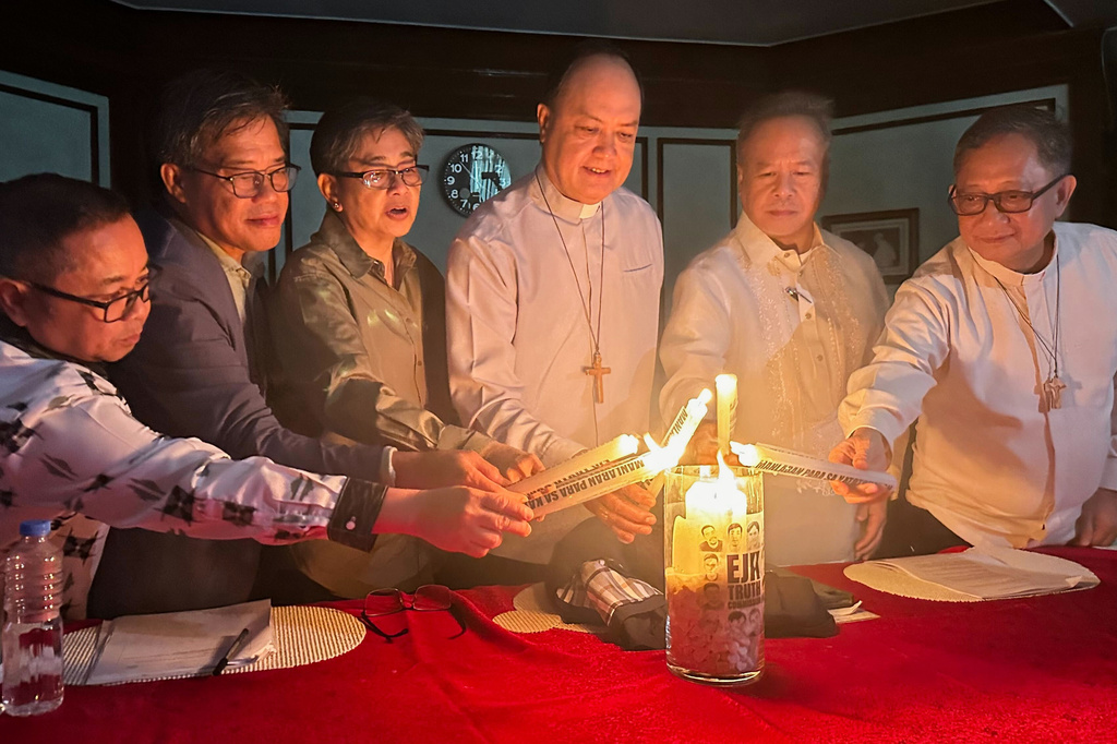 From left, Al Fuertes, Carlos Conde, Raquel Barros del Rosario-Fortun, Cardinal Pablo Ambo David, Raul Pangalangan and Fr. Daniel Franklin E. Pilario, light candles at a news conference to launch a fact-finding body to document details of former Philippine President Rodrigo Duterte's anti-drugs crackdown that can be used by the government to prosecute law enforcers in Manila, Wednesday, May 27, 2026. (AP Photo/Joeal Calupitan)