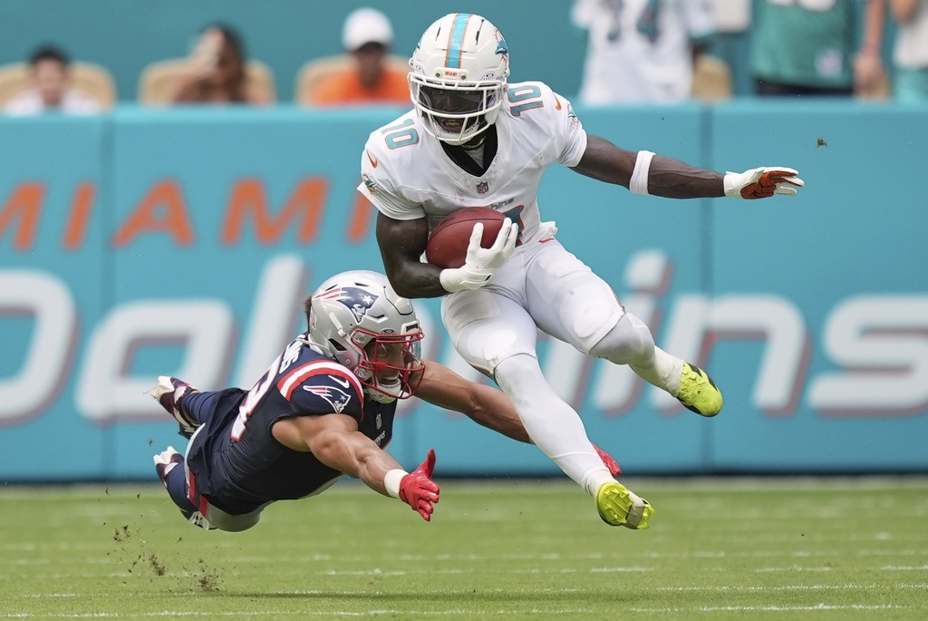 Miami Dolphins' Tyreek Hill gets past New England Patriots' Mack Hollins on a punt return during the second half of an NFL football game Sunday, Sept. 14, 2025, in Miami Gardens, Fla. (AP Photo/Rebecca Blackwell)