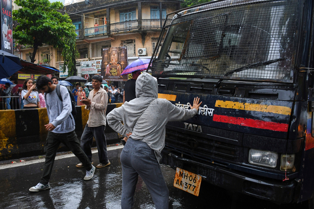 Rhiya Ahir, a model, blocks a police van carrying detained protesters during a demonstration demanding educational reforms as part of the Cockroach Janta Party's ongoing protest movement in Mumbai, India, Wednesday, July 22, 2026. (AP Photo/Ashish Vaishnav)