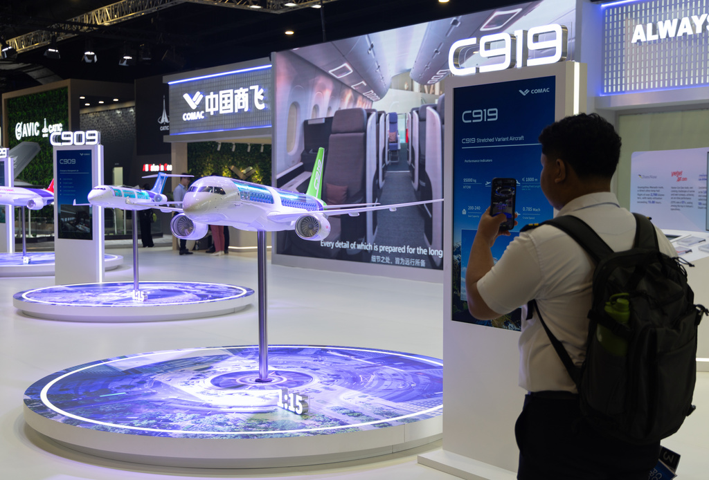 A pilot trainee takes a picture of a model of the Chinese-made C919 during the Singapore Air Show on Thursday, Feb. 5, 2026. (AP Photo/Anton L. Delgado)