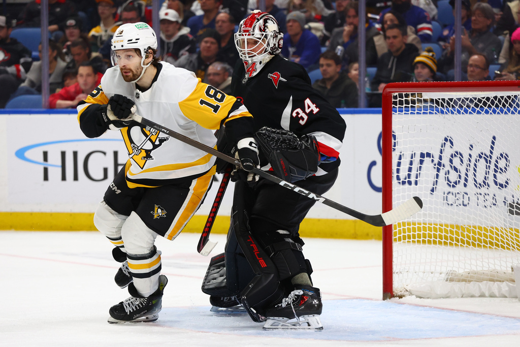 Pittsburgh Penguins center Tommy Novak (18) skates in the crease past Buffalo Sabres goaltender Alex Lyon (34) during the second period of an NHL hockey game, Thursday, Feb. 5, 2026, in Buffalo, N.Y. (AP Photo/Jeffrey T. Barnes)