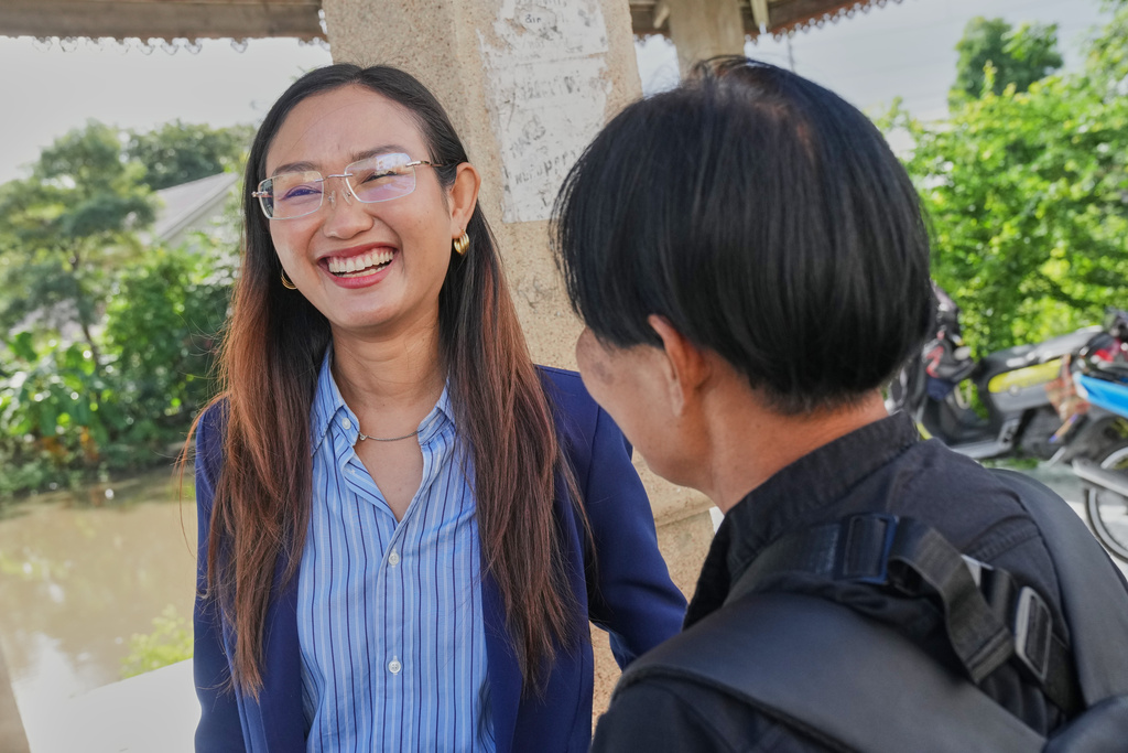 People's Party's Chonthicha Jangrew left, talks to her supporter upon her arrival outside the Thanyaburi Provincial Court in Pathum Thani province, north of Bangkok, Thailand, Tuesday, Sept. 30, 2025. (AP Photo/Sakchai Lalit)
