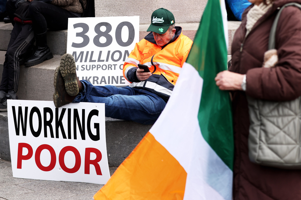 A protester sits on O'Connell Street in the heart of Dublin City center during the fifth day of a National Fuel Protest which has taken hold across Ireland, Saturday, April 11, 2026. (AP Photo/Peter Morrison)