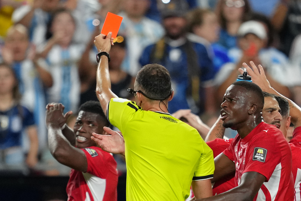 Referee Joao Pinheiro, of Portugal, gives a red card to Switzerland's Breel Embolo (7), left, during the World Cup quarterfinal soccer match between Argentina and Switzerland in Kansas City, Mo., Saturday, July 11, 2026. (AP Photo/Ed Zurga)