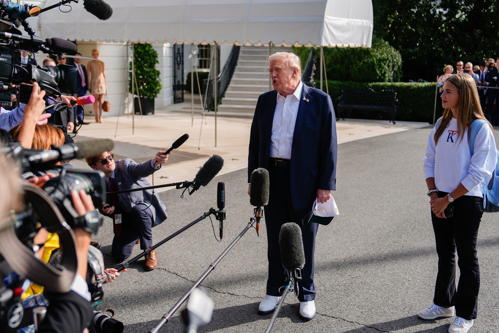 Kai Trump watches as her grandfather President Donald Trump speaks to reporters before departing the White House, Friday, Sept. 26, 2025, in Washington. (AP Photo/Julia Demaree Nikhinson)