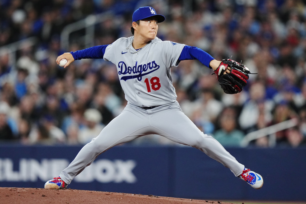 Los Angeles Dodgers pitcher Yoshinobu Yamamoto (18) works against the Toronto Blue Jays during the first inning of a baseball game in Toronto, Tuesday, April 7, 2026. (Nathan Denette/The Canadian Press via AP)