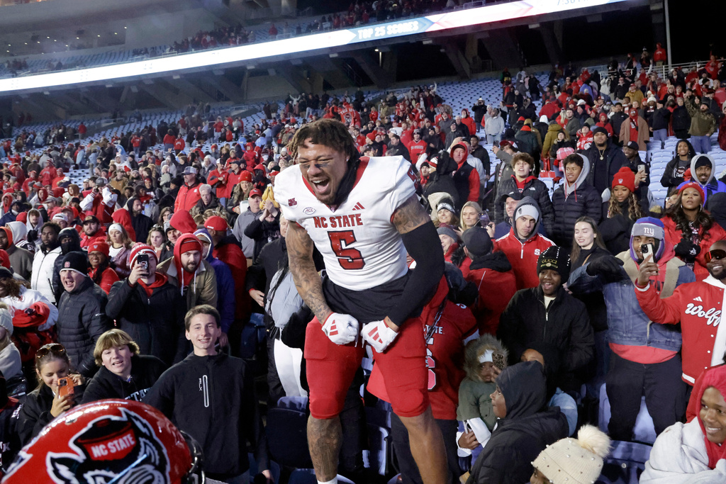 FILE -North Carolina State safety DK Kaufman (5) celebrates with the fans after defeating rival North Carolina in an NCAA college football game, Nov. 30, 2024, in Chapel Hill, N.C. (AP Photo/Chris Seward, File)