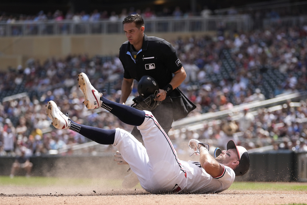 Minnesota Twins' Kody Clemens (18) lays on the ground after being tagged out by Athletics catcher Willie MacIver (65) to end the bottom of the fourth inning of a baseball game Thursday, Aug. 21, 2025, in Minneapolis. (AP Photo/Abbie Parr)
